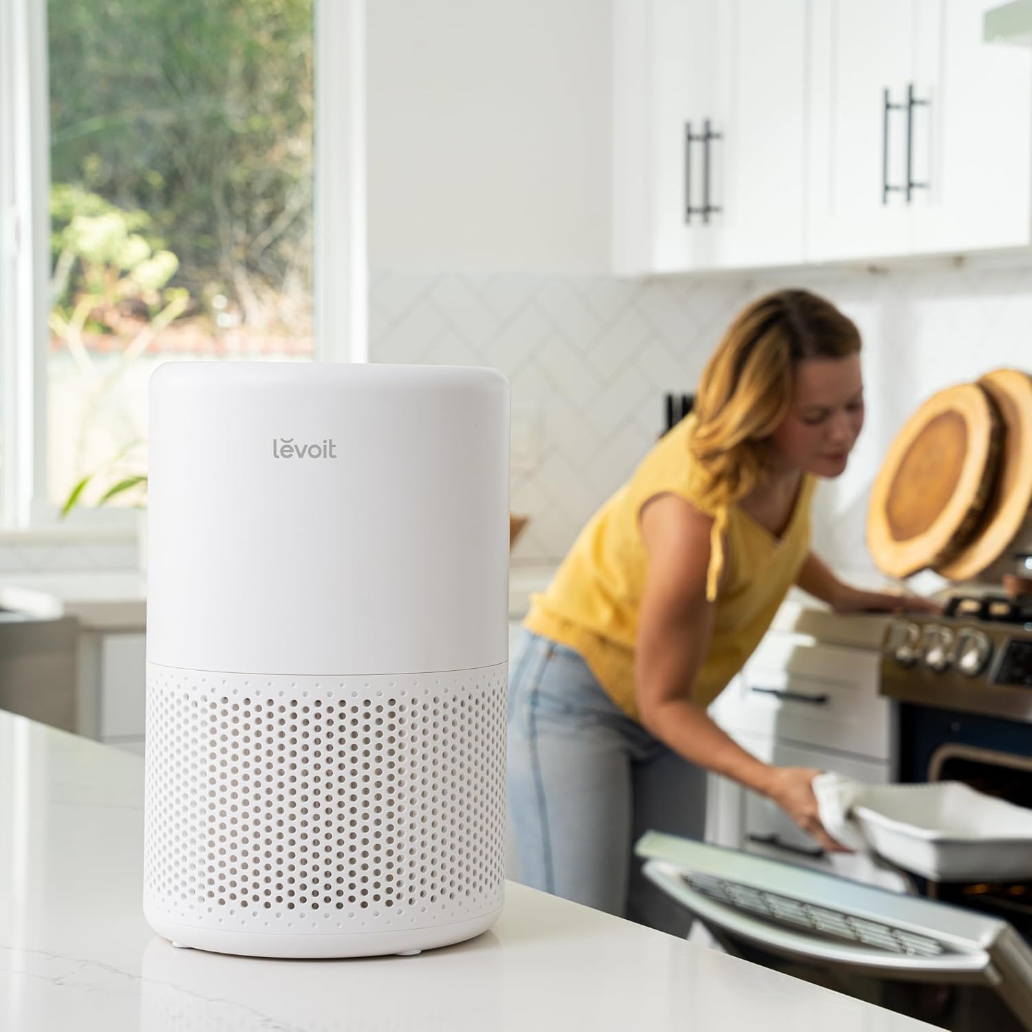 Levoit Core 200S Smart Air Purifier in kitchen, cleaning the air while user bakes, providing fresh air and reducing cooking odors, allergens, and dust.