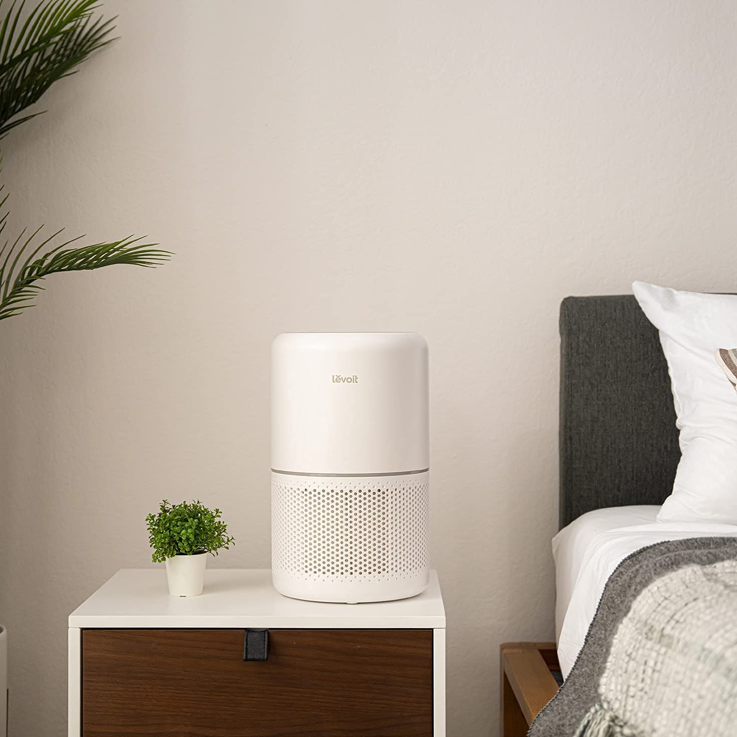 Levoit Core 300 Air Purifier placed in a bedroom, efficiently purifying the air on a bedside table, ensuring fresh and healthy indoor air.